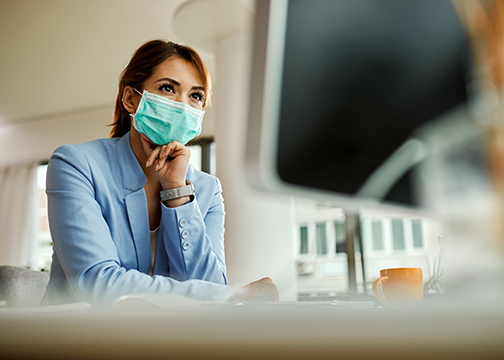 Below view of businesswoman wearing face mask while working on a computer.