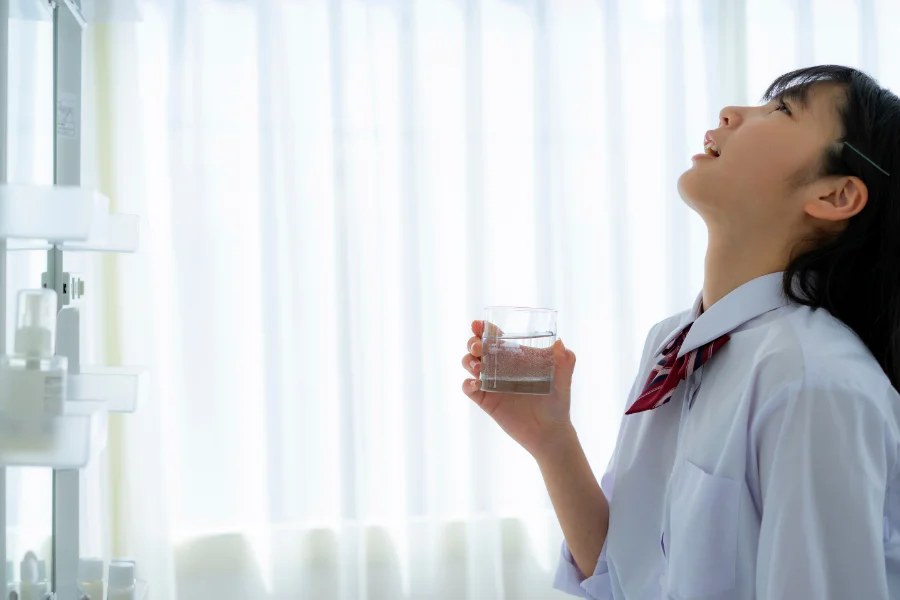 A woman gargling saline solution to relieve mucus in throat after acdf surgery