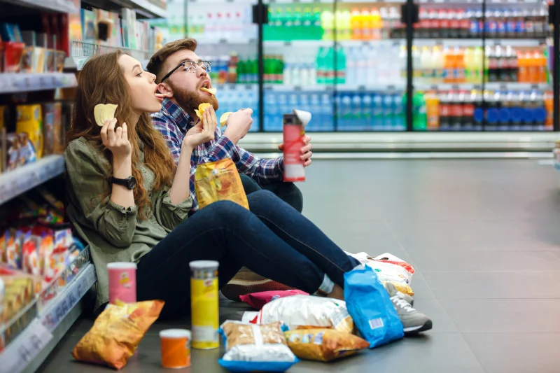 Two people eating junk food instead of trying to get rid of metallic taste