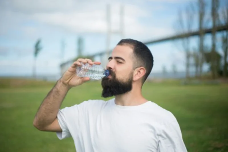A man drinking water after taking his allergy medications
