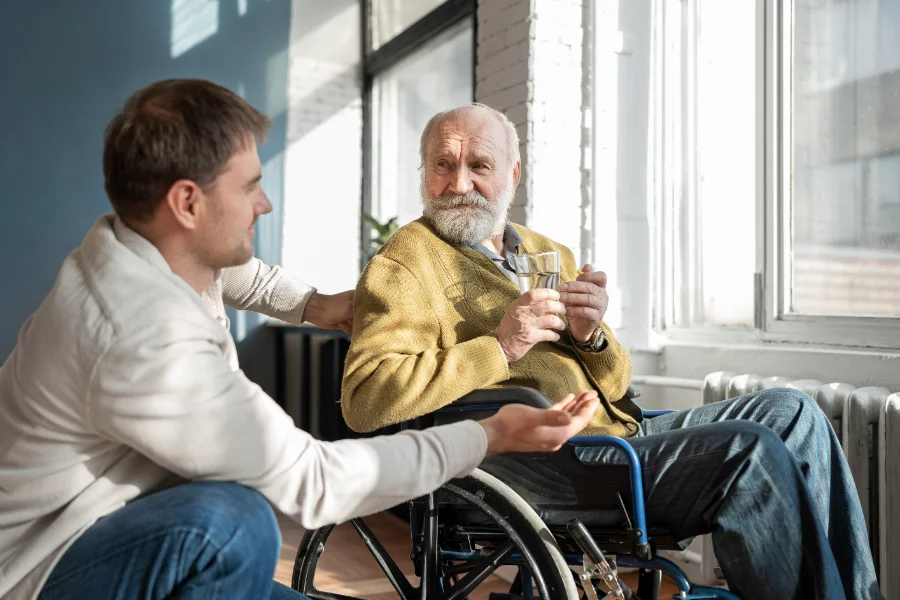 An old man in a wheelchair taking Parkinson's disease medication.