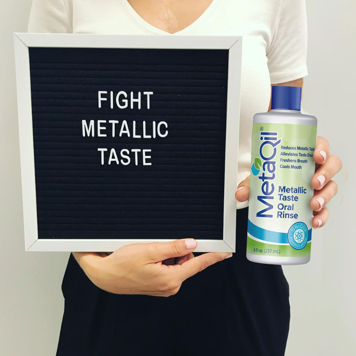 A sign that says, “Fight Metallic Taste” A.K.A. dysgeusia and a bottle of MetaQil oral rinse for alleviating metallic taste symptoms.