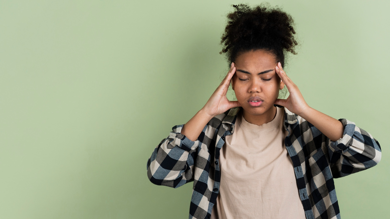 A woman experiencing one of the Side effects of Paxlovid, headaches. 