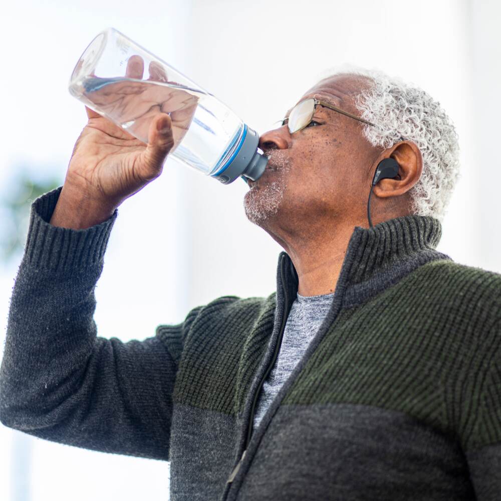 A man drinking water in an attempt to alleviate his Altered Taste.