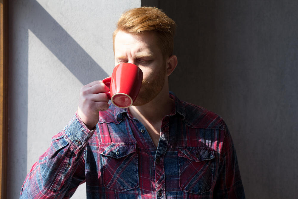 A man drinking and experiencing metallic taste coffee. 