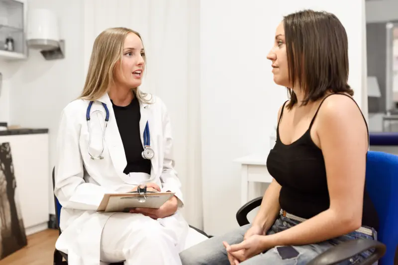 A woman with a strange bitter taste in mouth discussing the issue with her doctor.