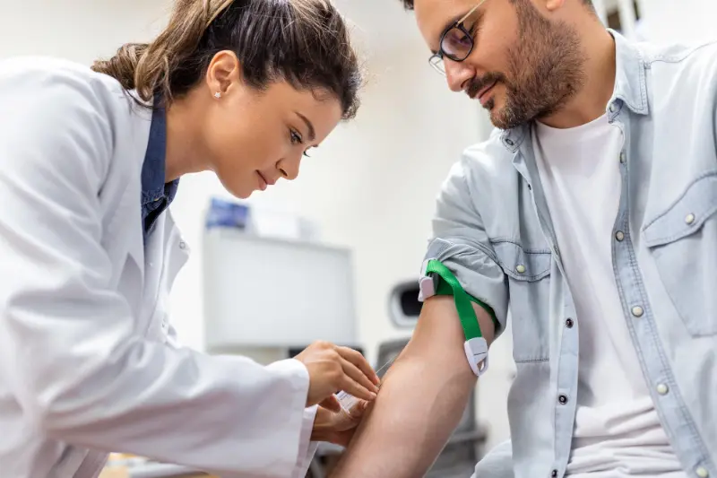 A man with a bitter taste in mouth getting bloodwork done. 
