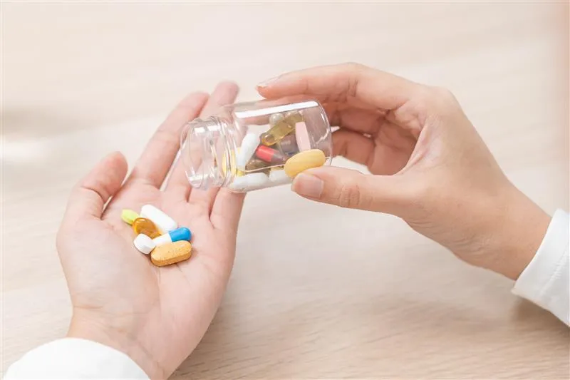 AdobeStock_1651089044 | MetaQil Assorted vitamins and mineral supplements in the hands of a person experiencing metallic taste after supplements.